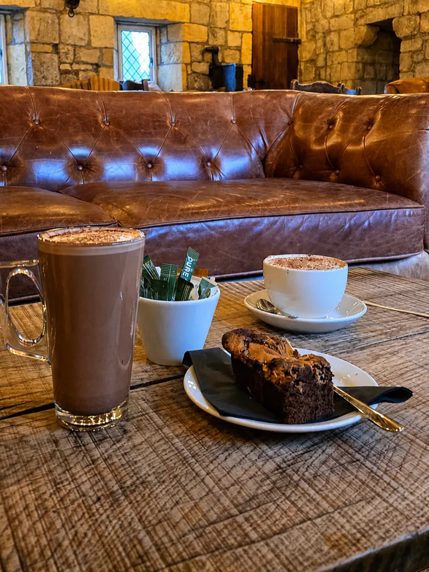 Coffee and cake beside leather seating in Gatehouse Coffee